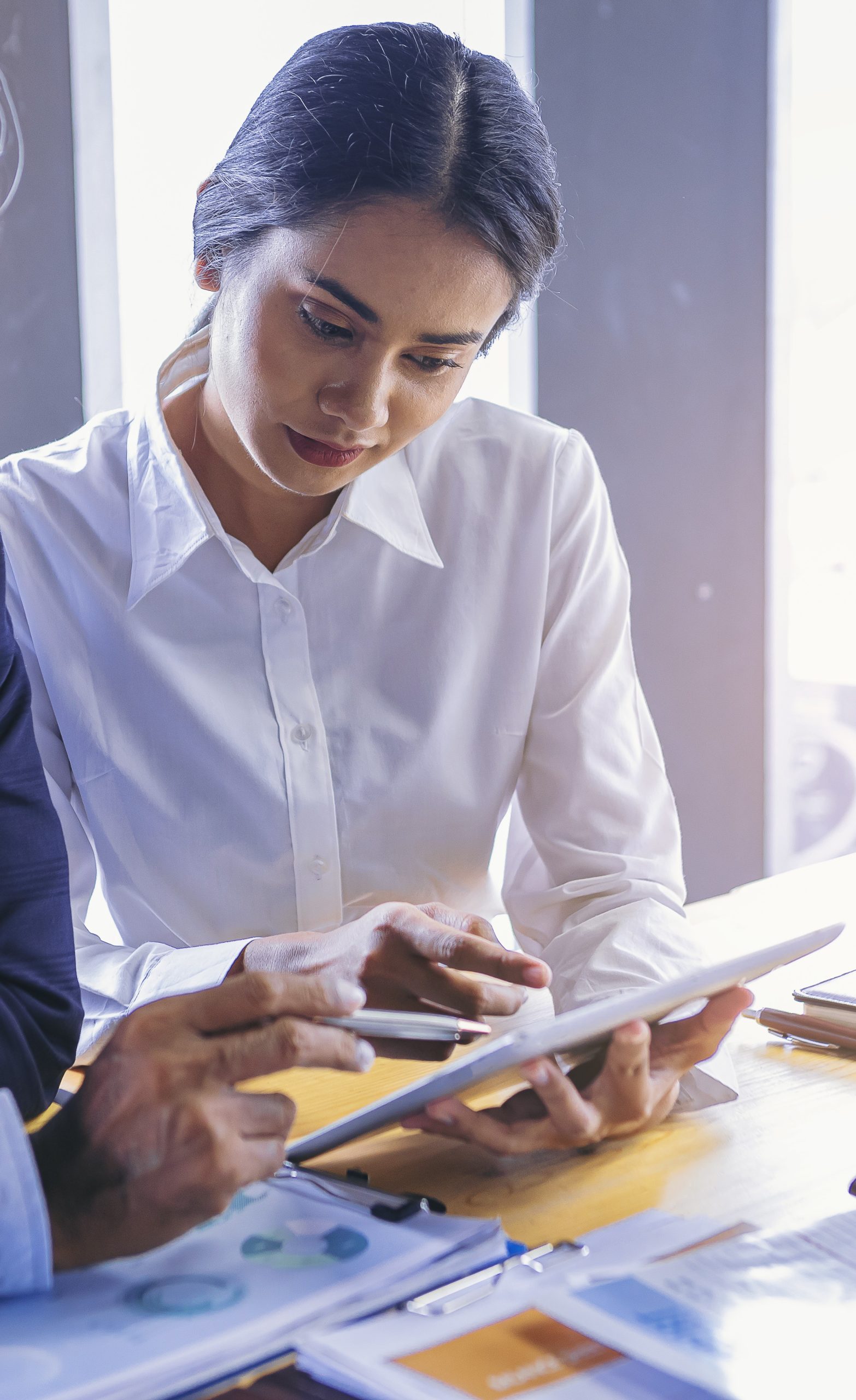 young-attractive-businesswoman-working-with-touchpad-has-been-guided-consulting-by-colleague